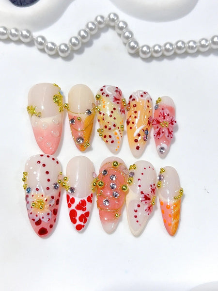Blossom Elixir Press-On Nägel Mandelform lang, Orange, Rot und Gelb mit Blüten, Perlen und goldenen Akzenten