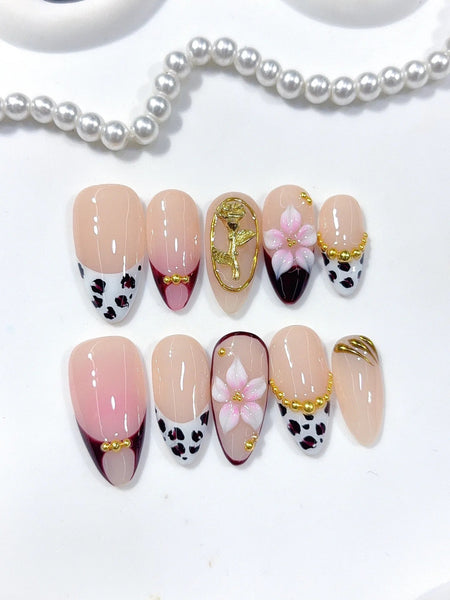 Wildflower Noir Press-On Nägel Mandelform mittellang, Schwarz, Weiß und Pink mit Blütenmotiven und goldenen Akzenten
